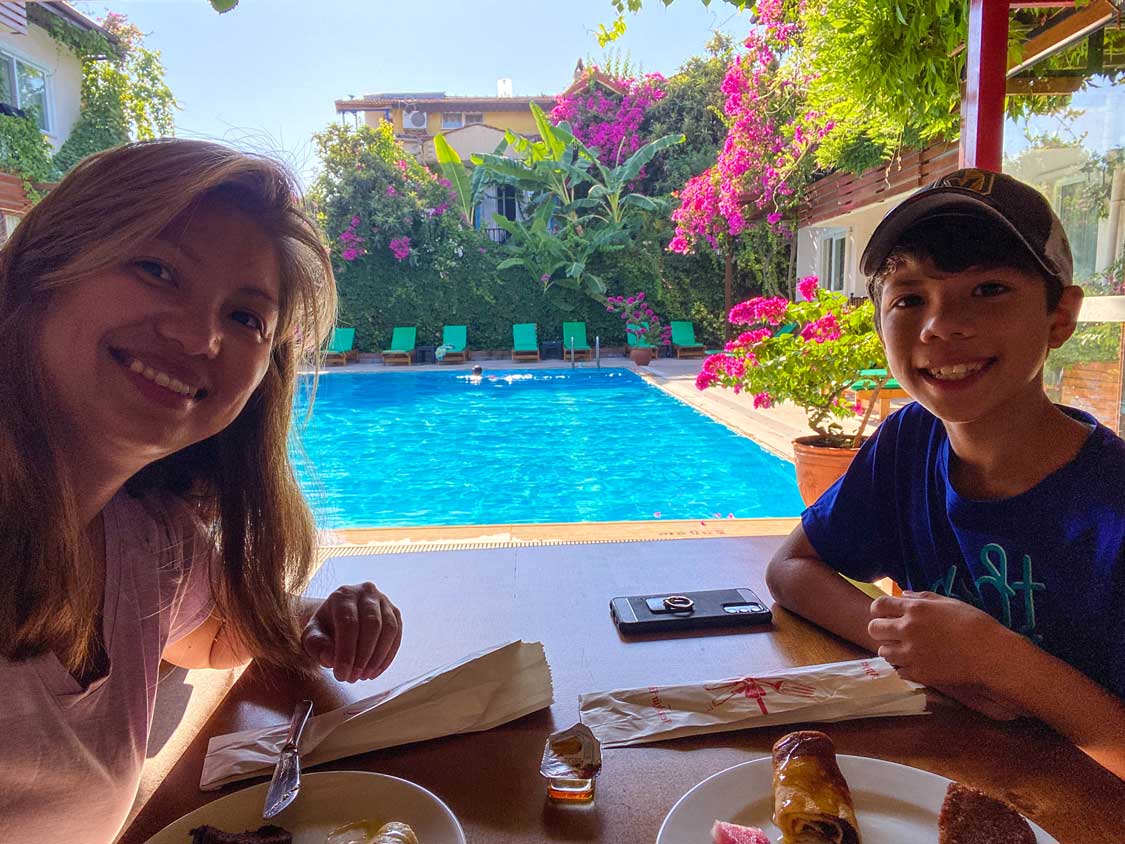 A woman and her son smile while sitting by the pool of Ten Apart Hotel in Fethiye