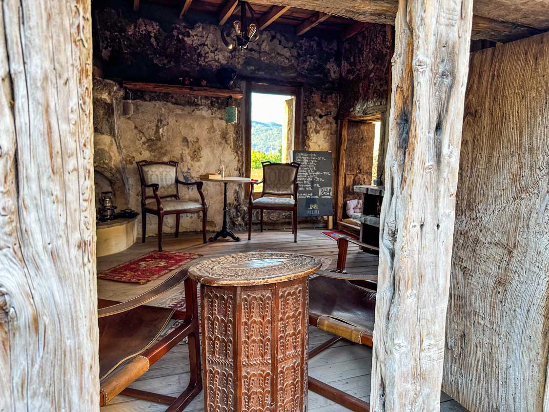 A few chairs and tables inside the remains of a building in Kayakoy have been converted into a small restaurant