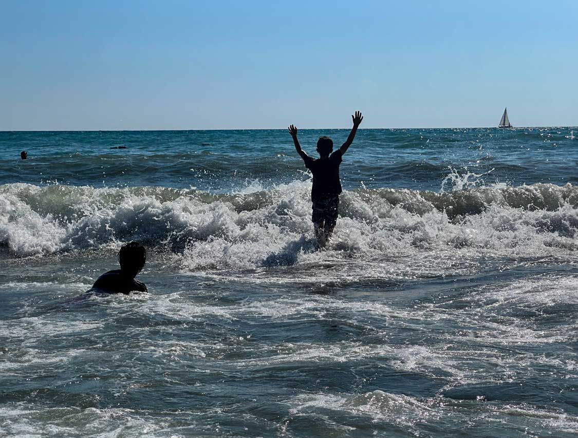 Kids jump in the waves at Patara Beach near Fethiye