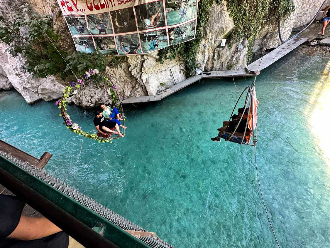 A couple of a makeshift swing get their photo taken at the entrance to Saklikent Gorge