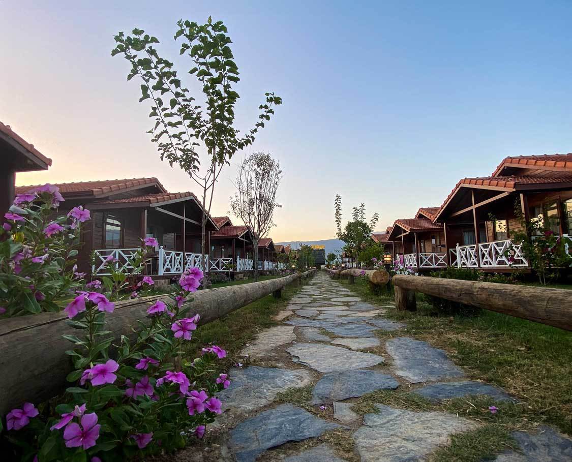 A row of cabins lined with flowers at Marti Bungalow in Demre Turkiye