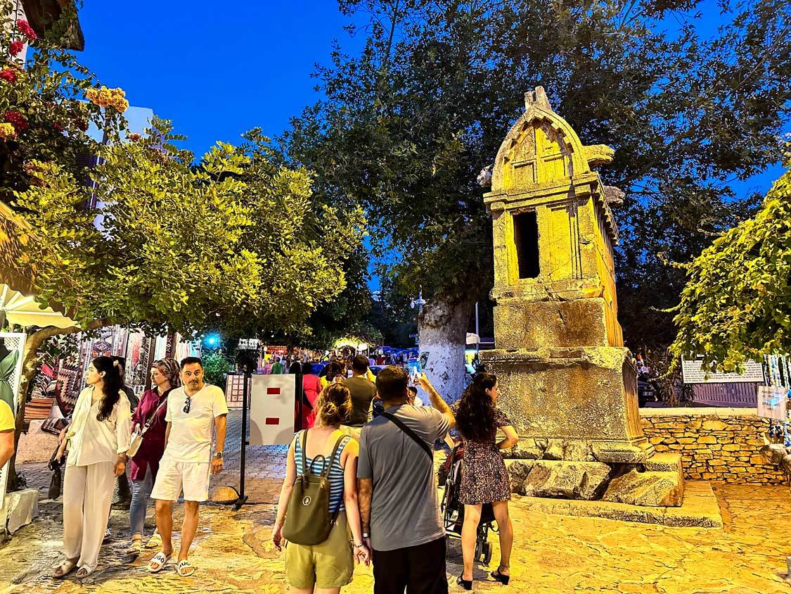 Tourists take photos of a Lycian tomb on one of the streets in Kas