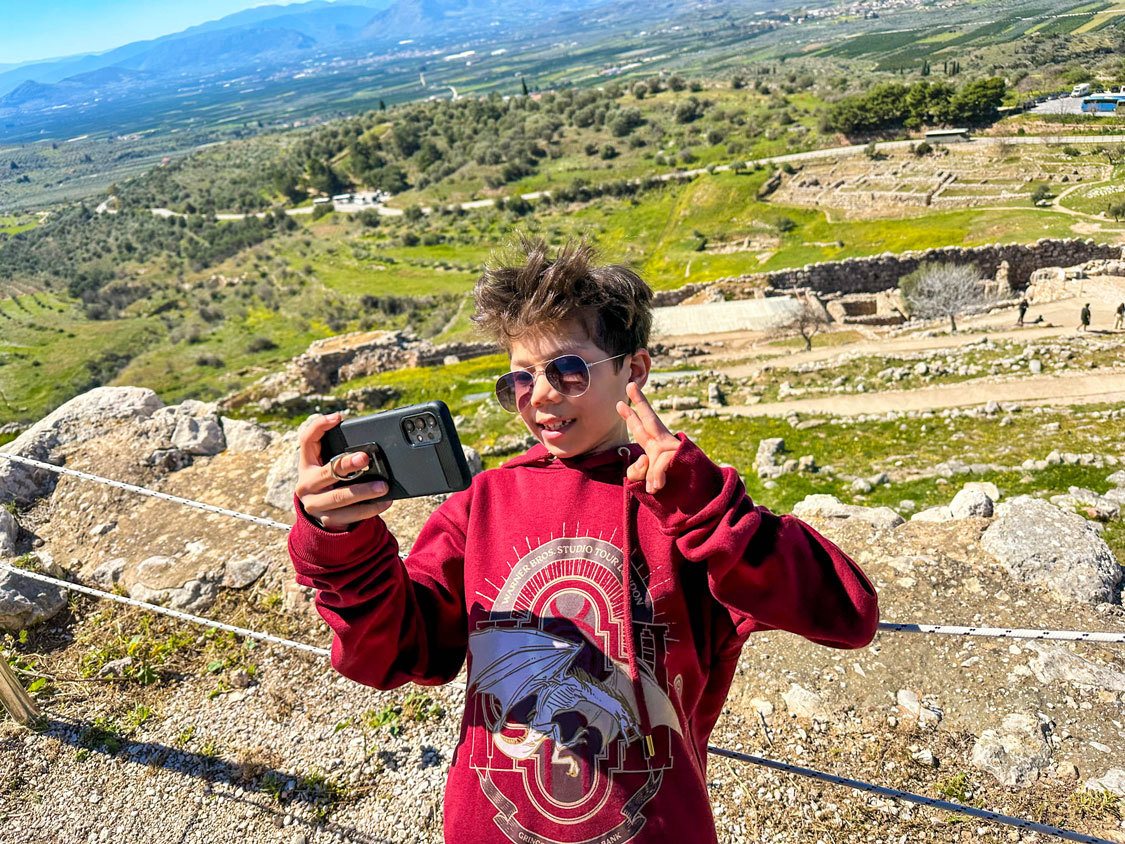 A young boy takes a selfie at the ruins of Mycenae in Greece