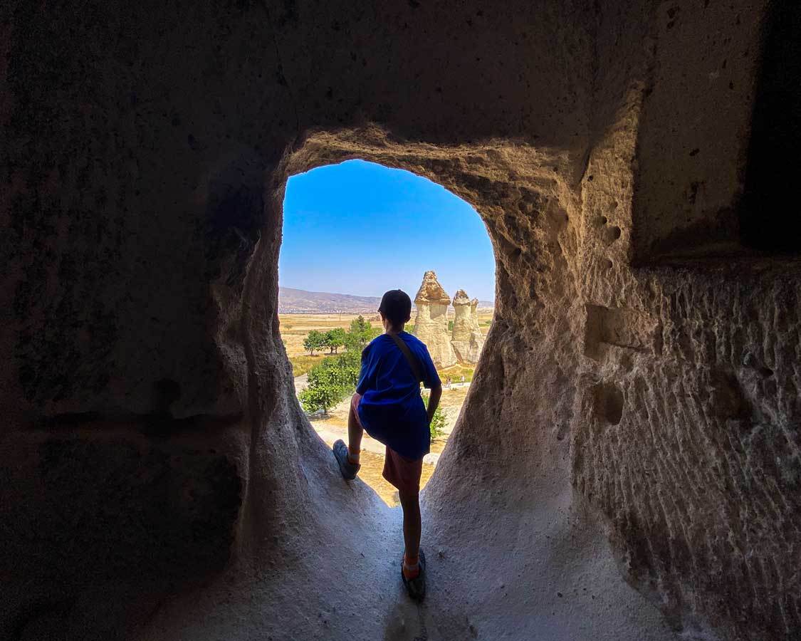 A boy looks out from a window in a cave house in Pasabag, Turkiye