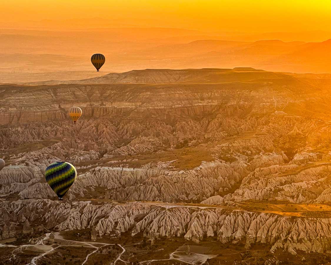 Hot air balloons float over the valleys of Cappadocia, Turkiye