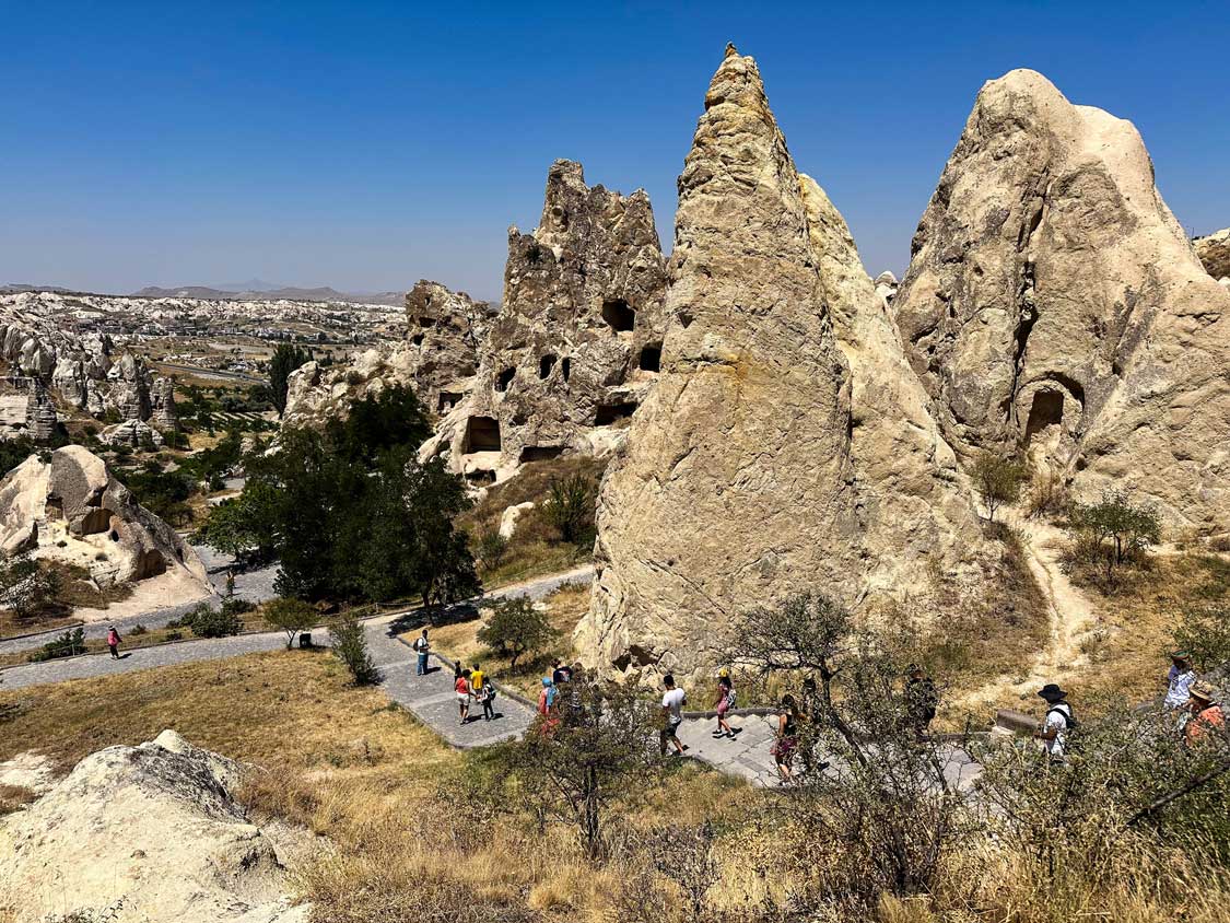 Tourists walk around fairy chimneys at the Goreme Open Air Museum