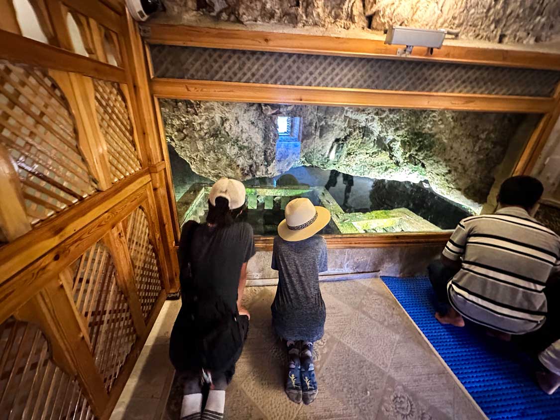 Two boys look into Abraham's Cave, believed to be where the Prophet Abraham was born