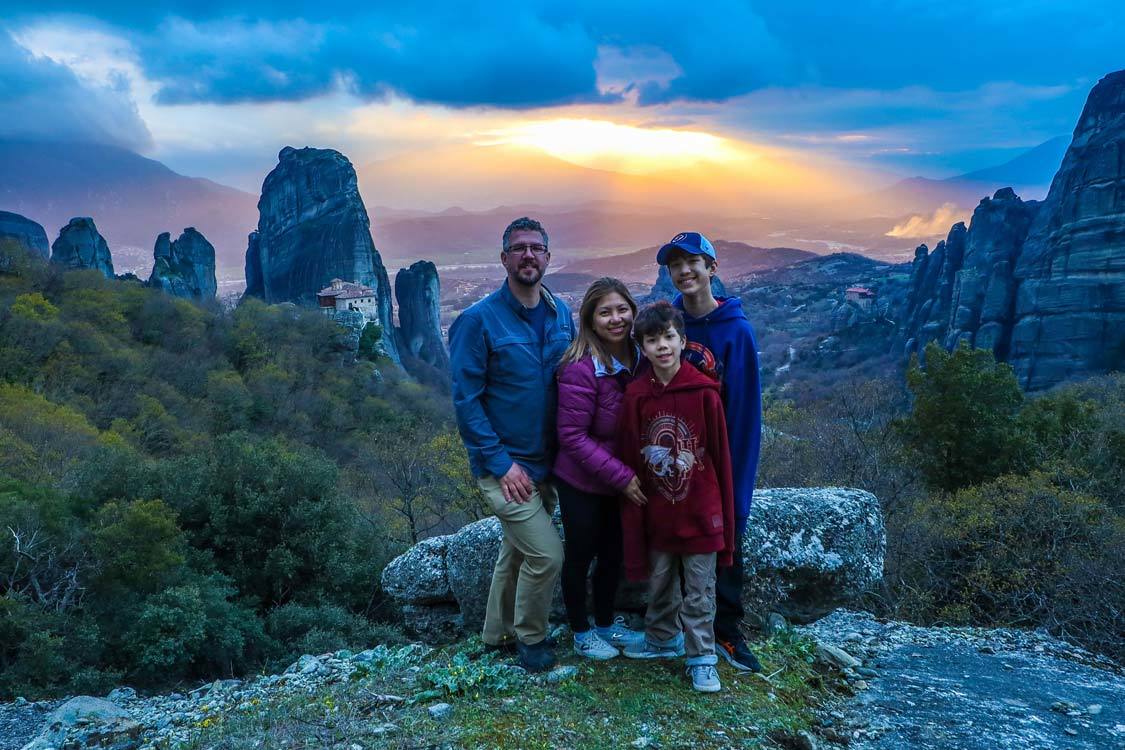 The Wandering Wagars travel family poses in Meteora Greece at Sunset