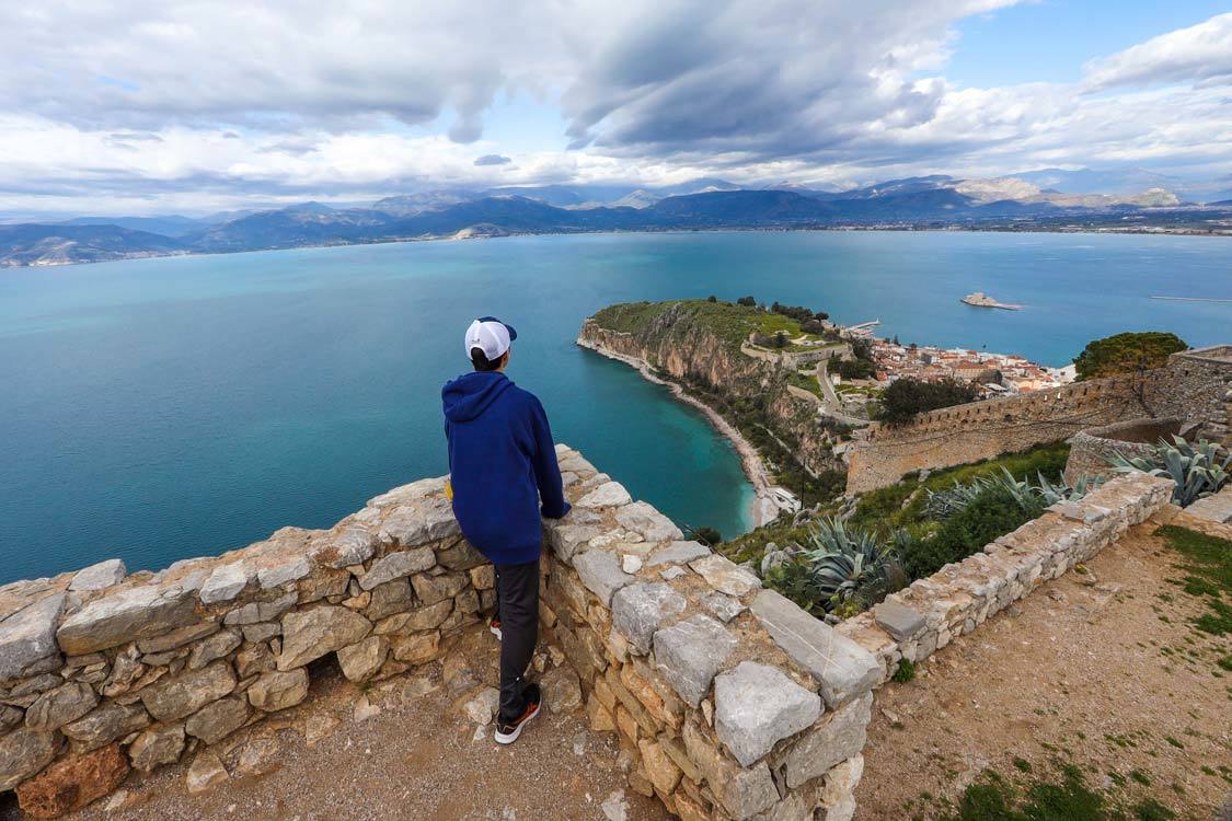 A boy looks out from the walls of Palamidi Fortress over the town of Nafplio