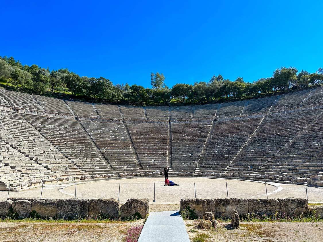 A woman sings at an empty Epidaurus Theater