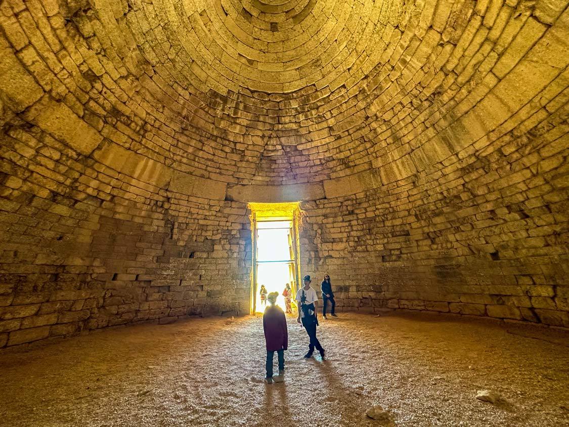 Two boys walk inside the Tomb of Agamemnon in Mycenae, Greece