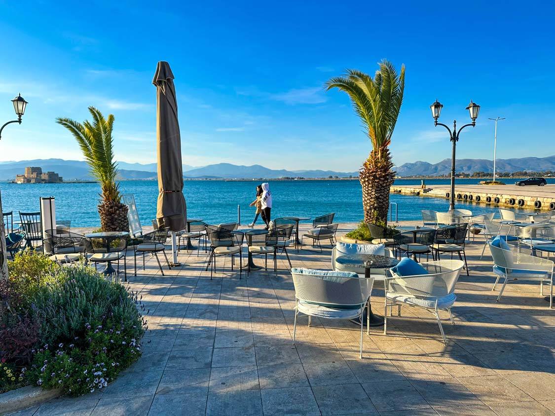 Chairs and tables dot the waterfront of Nafplio, Greece