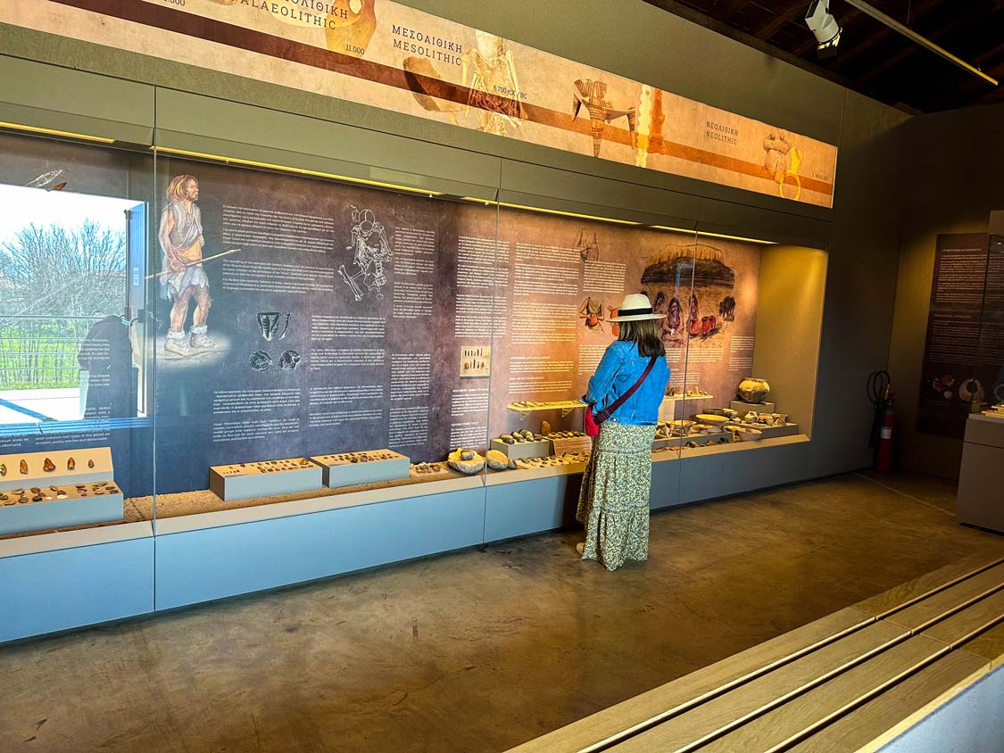 A woman wanders through a museum display at Theopetra Cave in Meteora, Greece