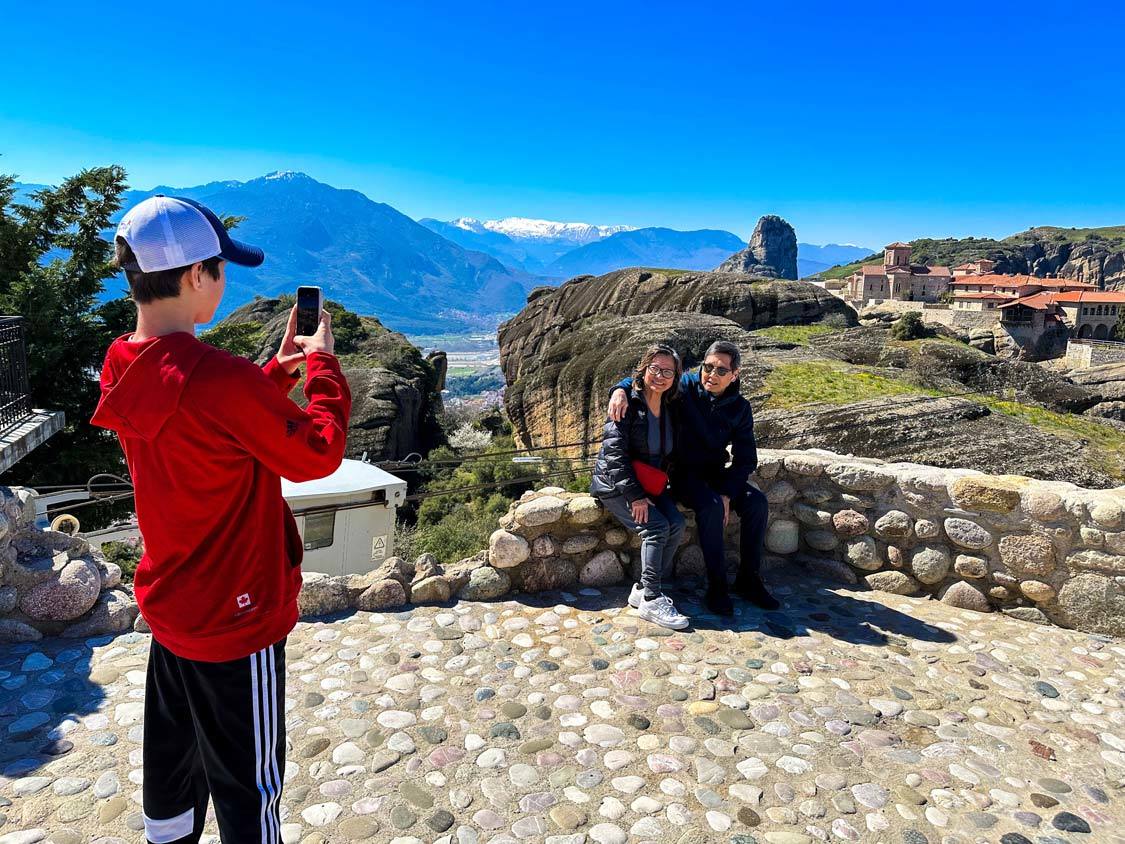 A boy takes a photo of his grandparents at the Monastery of the Holy Trinity