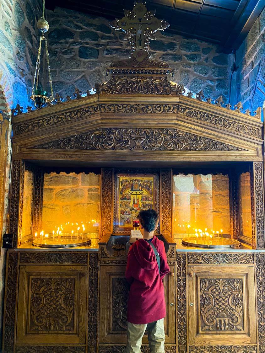 A young boy standing in front of an altar at Varlaam Monastery