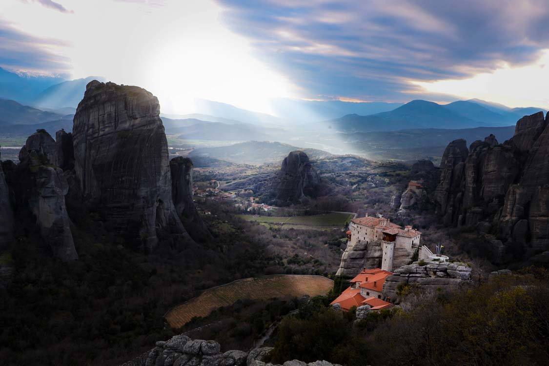 The monastery of the Grand Meteoron lit by a ray of sunshine over the Meteora landscape