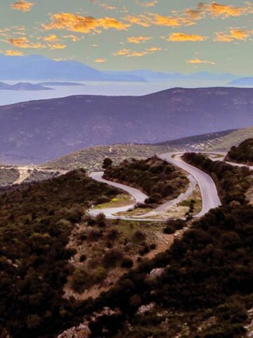 Winding roads at sunset over the Aegean Sea on a Greek road trip