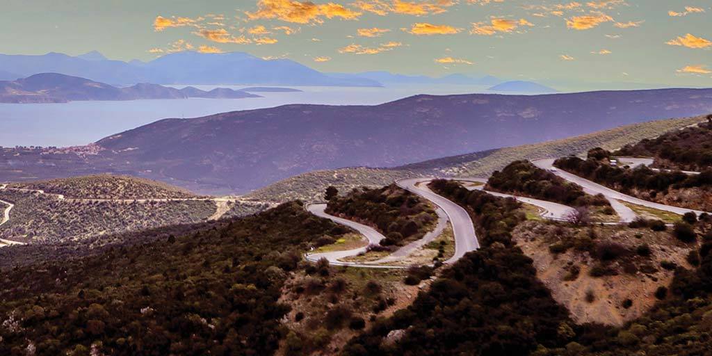 Winding roads at sunset over the Aegean Sea on a Greek road trip