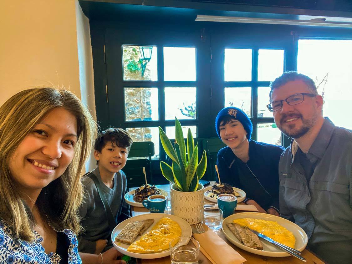 A family takes a photo during breakfast at Myrtillo Cafe in Monemvasia