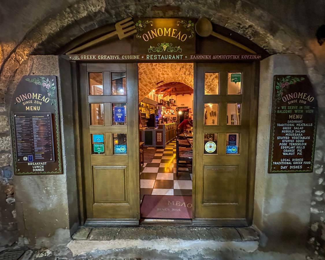 Looking into Oinomelo, historic Greek restaurant through an open door