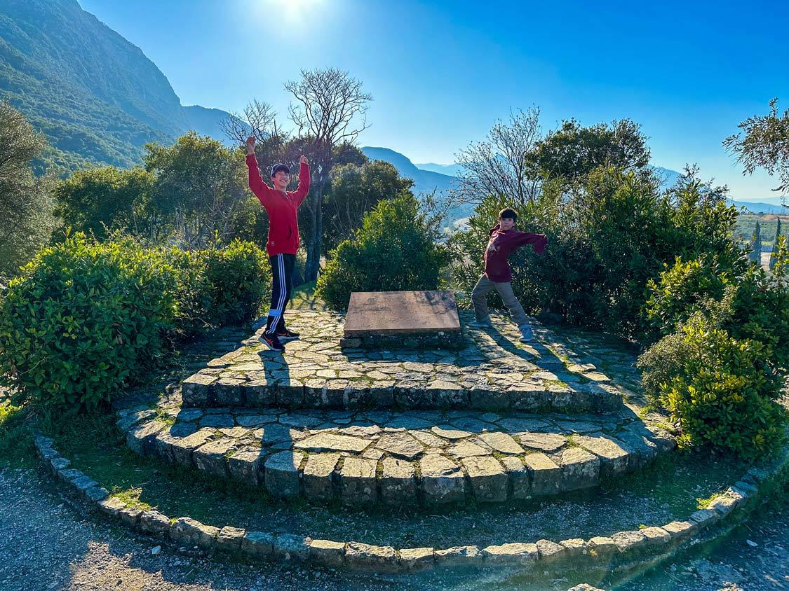 Two boys pose dramatically at the hill of Kolonos