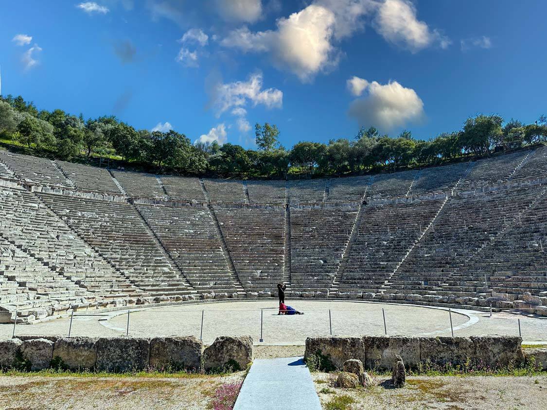 A family sings at the center of the Epidaurus Theater