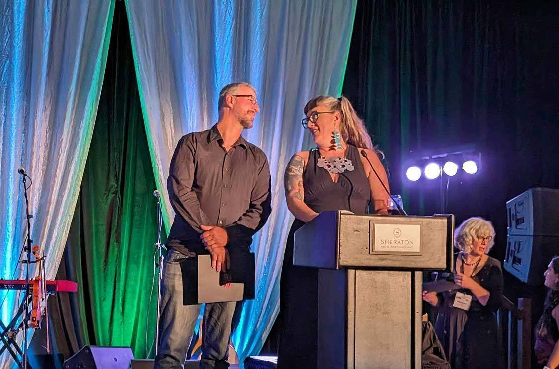 Kevin Wagar accepts a TMAC travel media award from Jodi Holiday in St. Johns Newfoundland