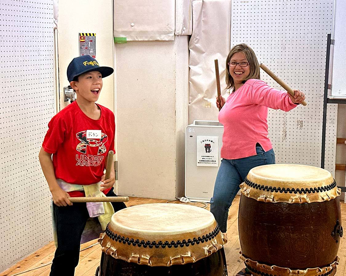 A mother and son play drums at a Japanese drum school in Tokyo, Japan