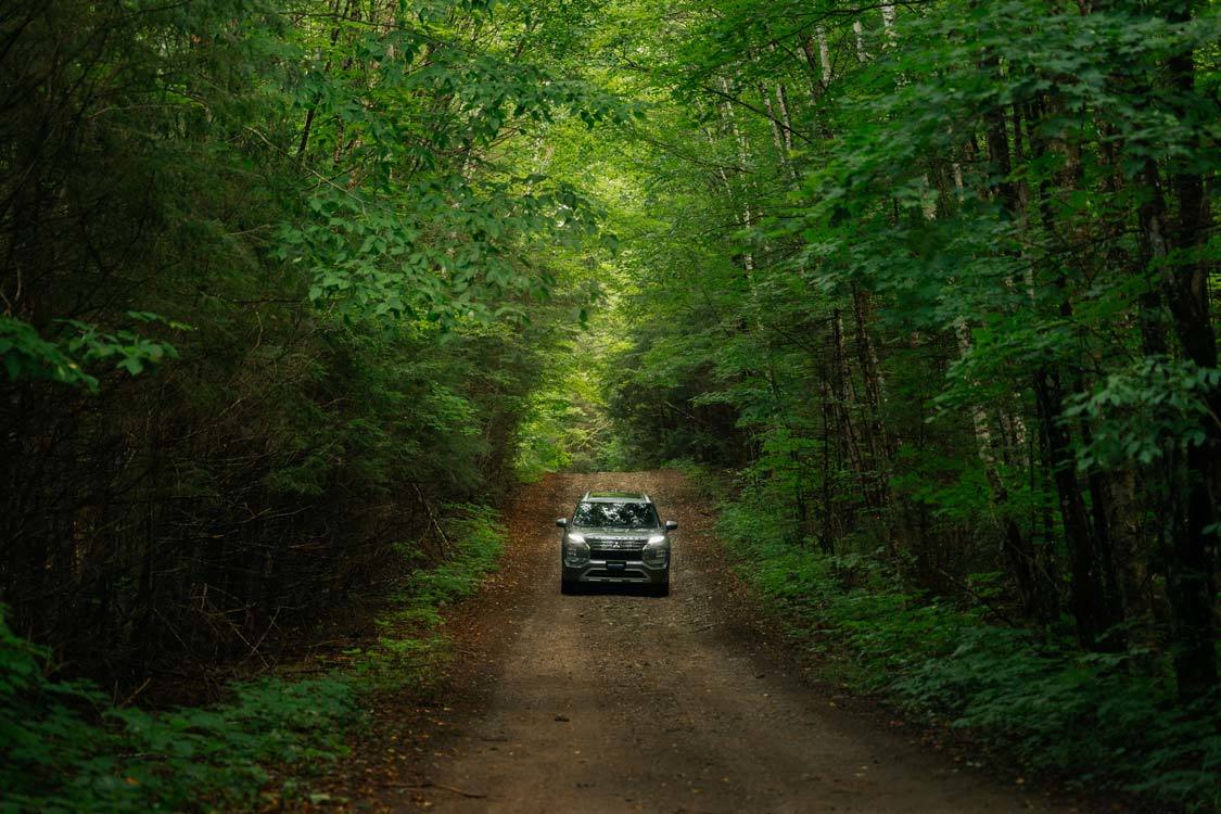 A 2024 Mitsubishi Outlander PHEV drives through the Muskoka forests in Ontario