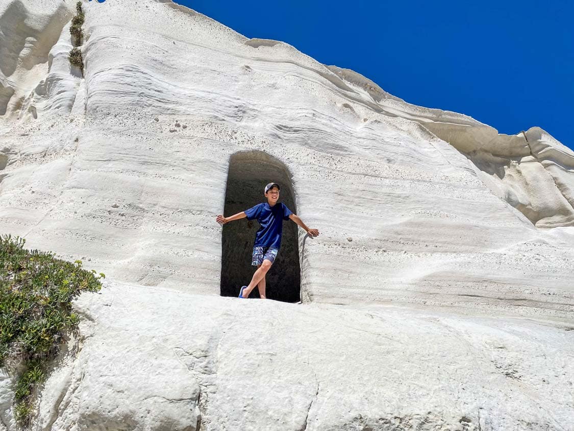 A boy explores the mines at Sarakiniko Beach