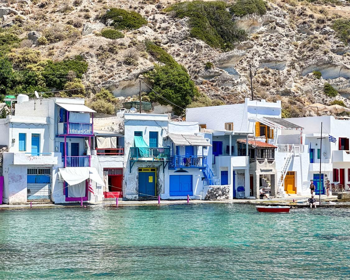 Colorful syrmata line the waters of Klima on Milos, Greece