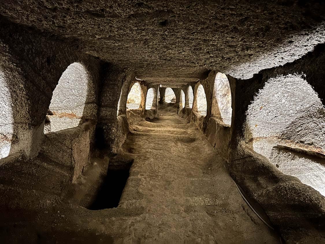 Tombs are lit up inside the Catacombs of Milos in Greece