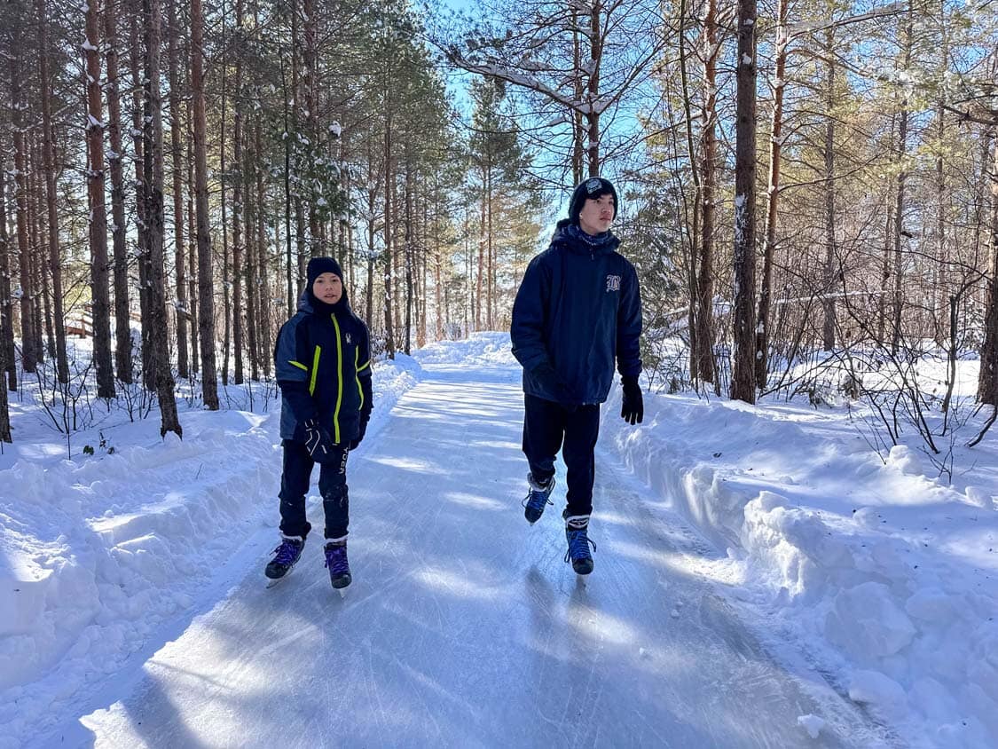 Two boys skating through forest trails at Domaine Enchanteur