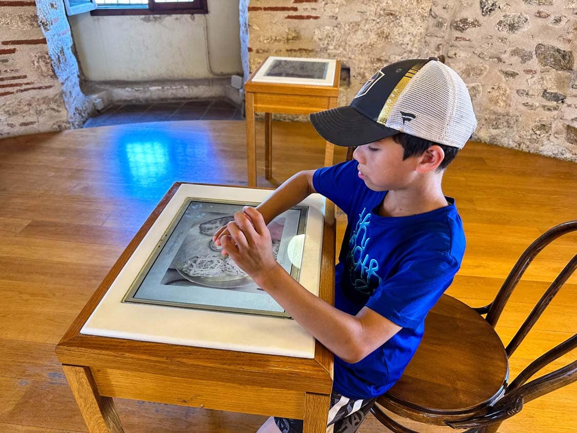 A young boy reads a display at the White Tower museum in Thessaloniki