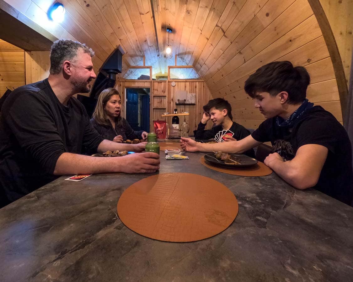 A family eating dinner together in a cozy cabin in the woods