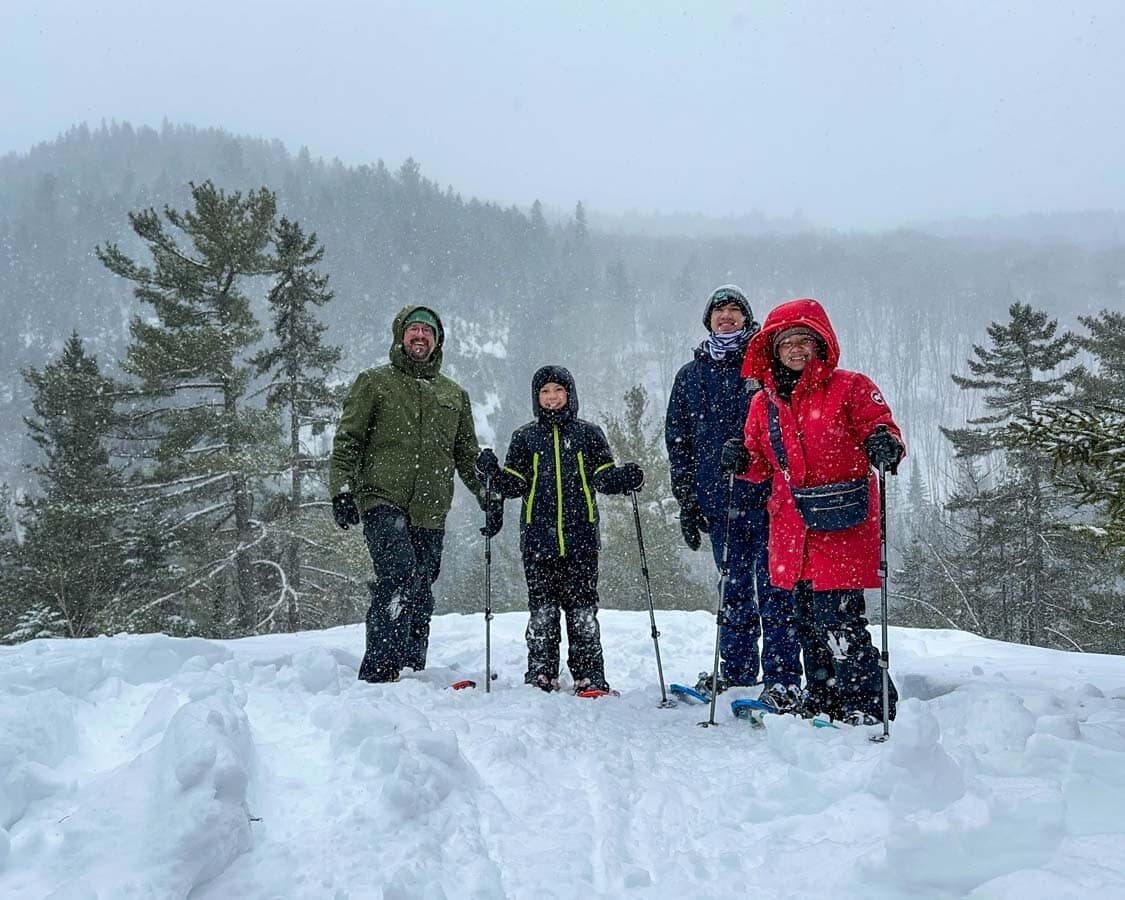 A family snowshoeing through the mountains of Lanaudiere, Quebec