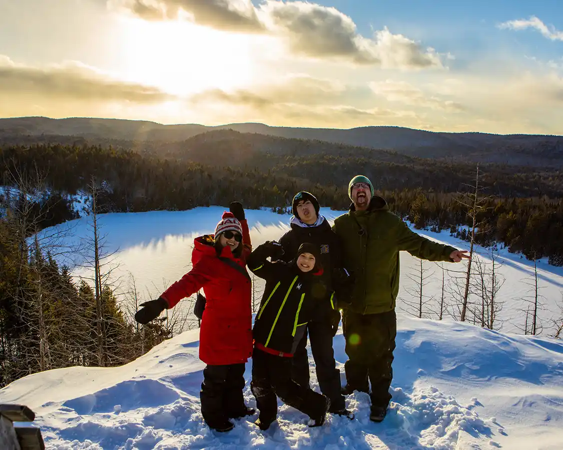 A family celebrates after hiking the Lac Solitaire Trail at La Mauricie National Park in the winter