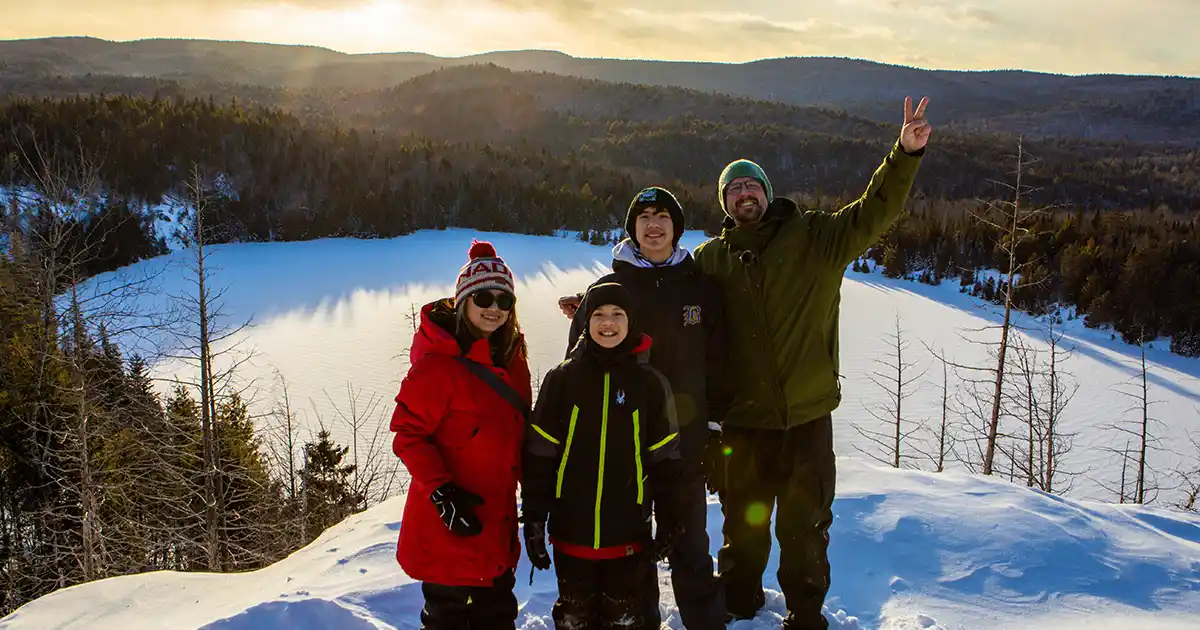 Family hiking at sunset in La Mauricie National Park during winter