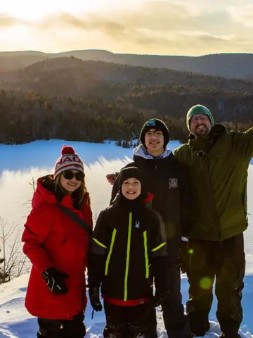 Family hiking at sunset in La Mauricie National Park during winter