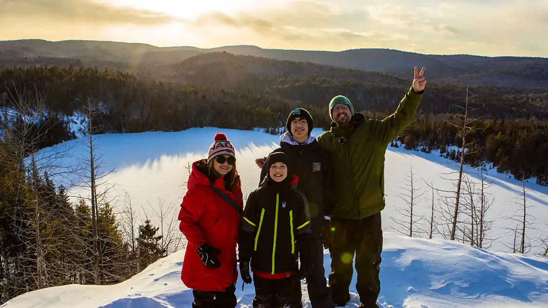 Family hiking at sunset in La Mauricie National Park during winter