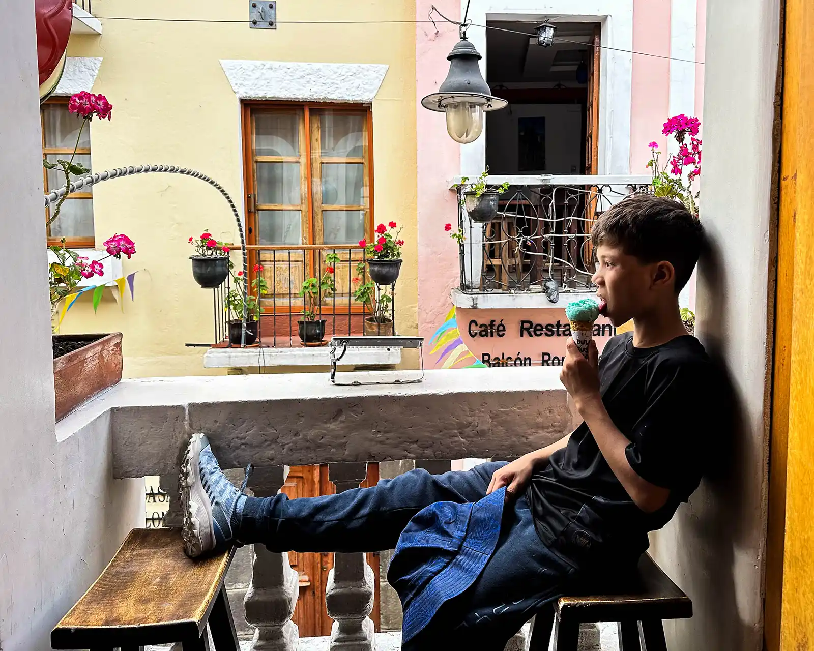 Boy eating ice cream at an open window in Quito Ecuador