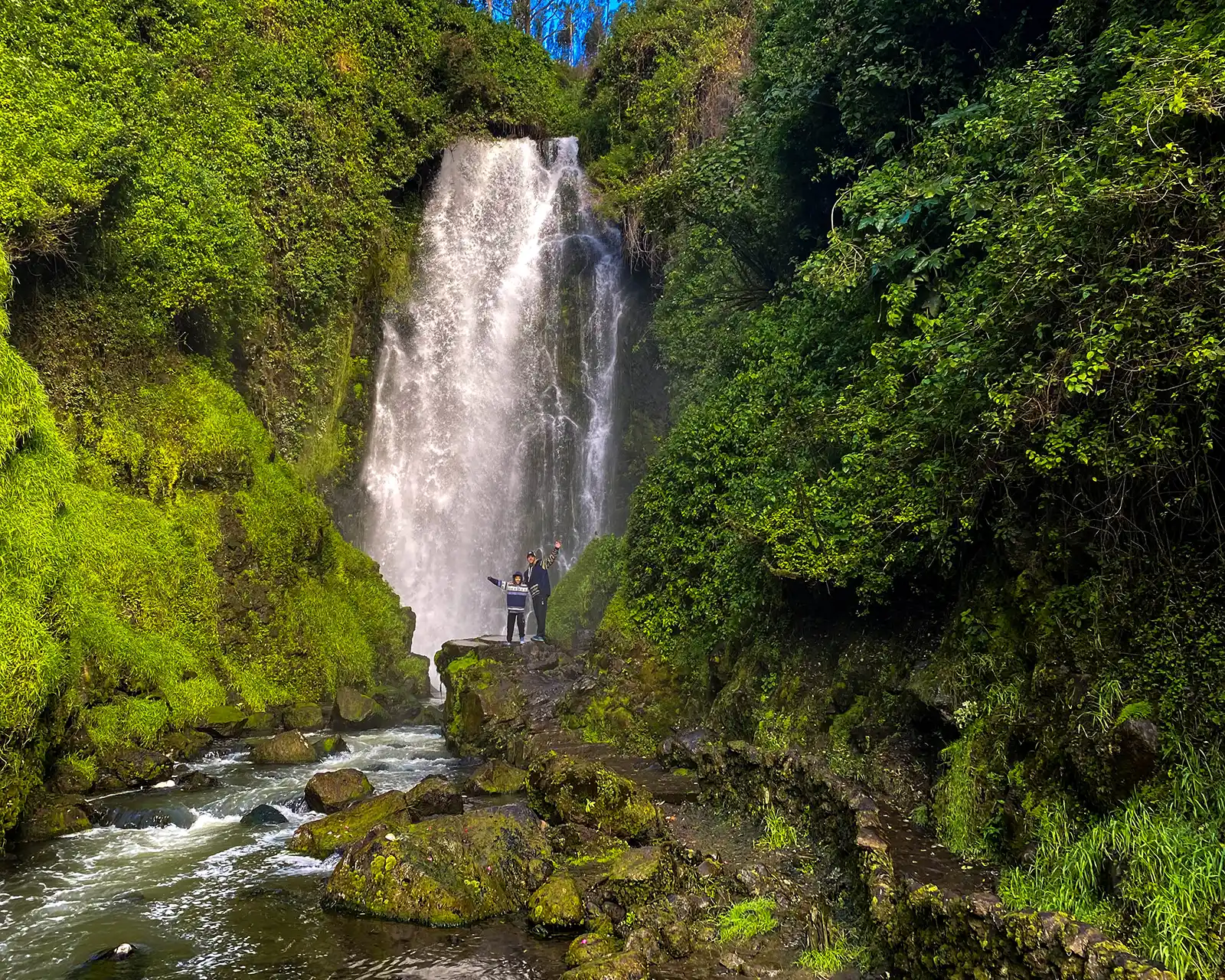 Two boys hike to the base of Cascada de Pechuda in Otavalo