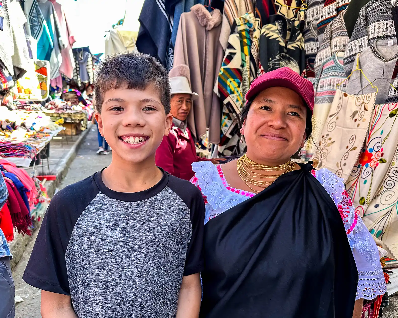 A boy poses with a market worker at the Otavalo textile market