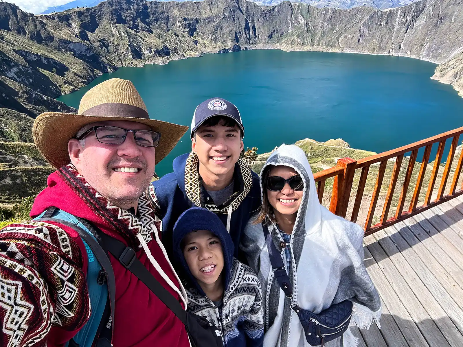 A family smiles for a photo at Quilatoa Crater Lagoon