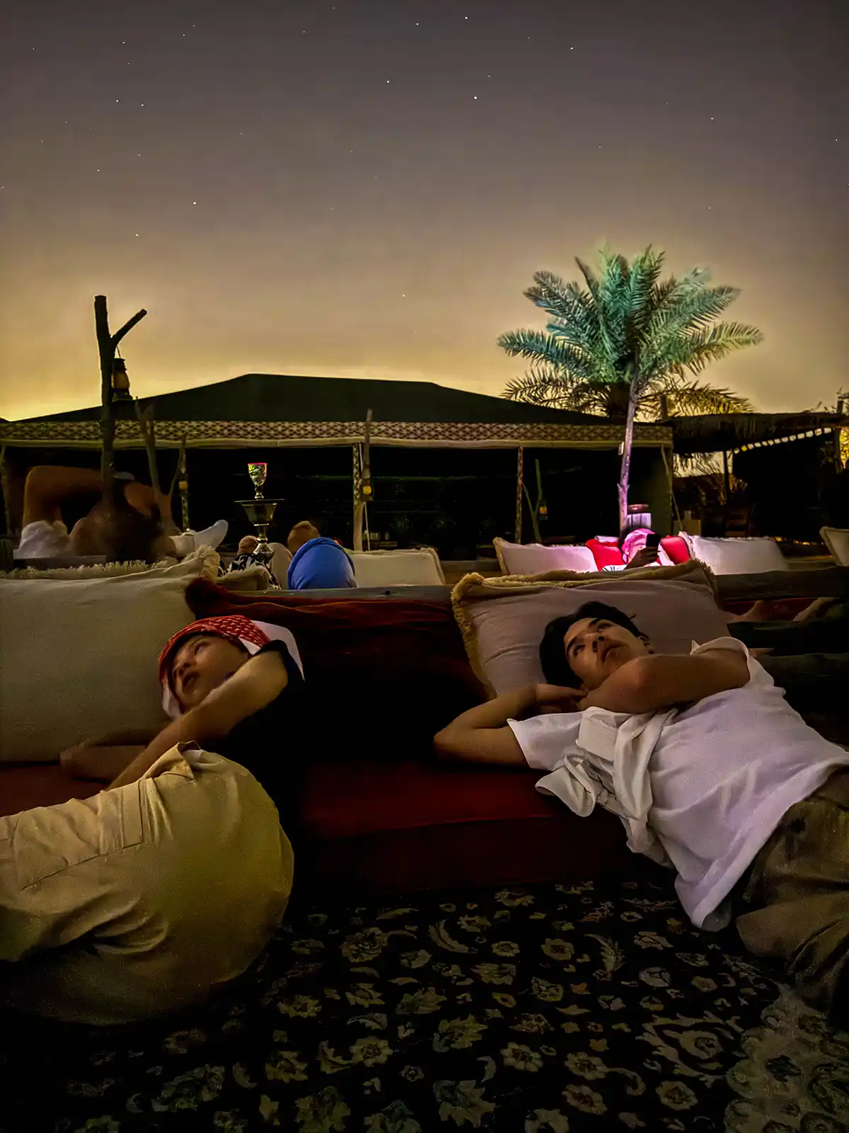 Two boys lie under the stars during a stargazing presentation on a Dubai desert tour