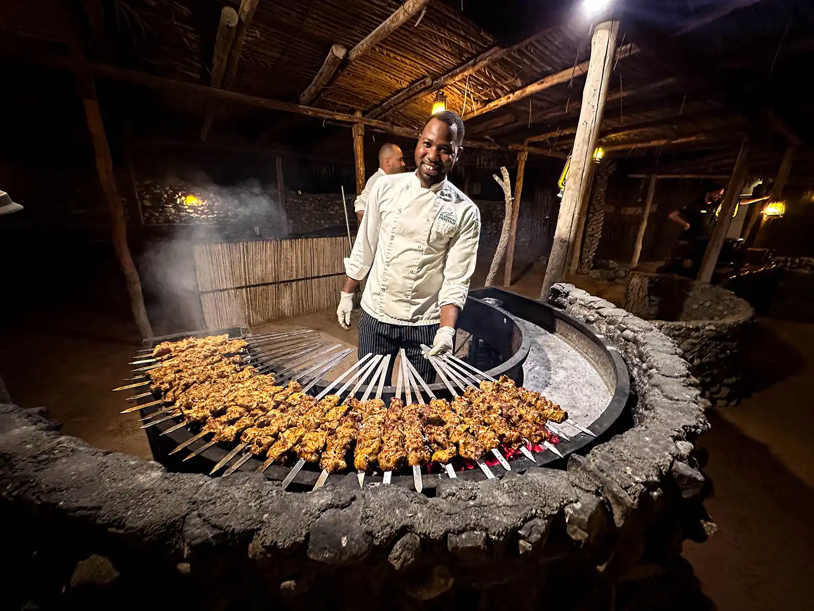 A chef grills up lamb kebabs at the Platinum Heritage Desert Camp