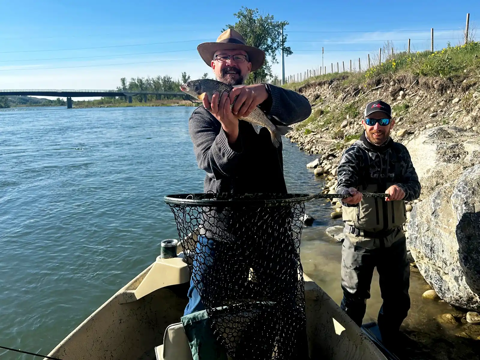 Kevin Wagar holds up a freshly caught Whitefish while Josh Nugent of Out Fly Flishing stands ready with a net