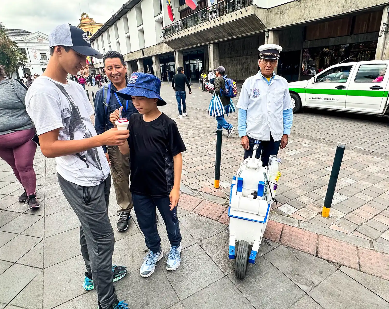 Boys buying ponche from a vendor at Plaza Grand in Quito