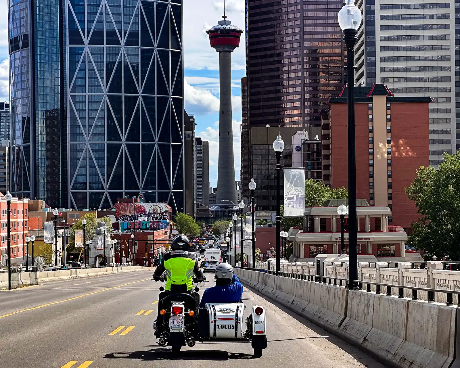 A motorcycle and sidecar ride toward the Calgary Tower