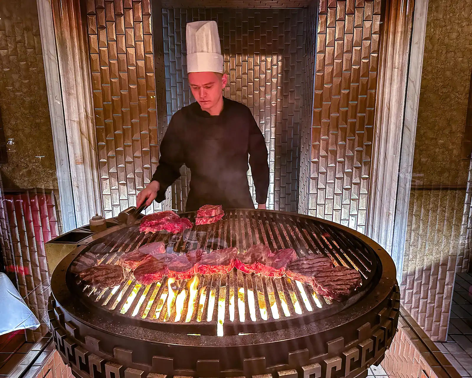 Grill chef cooking steaks at Caesar's Steakhouse
